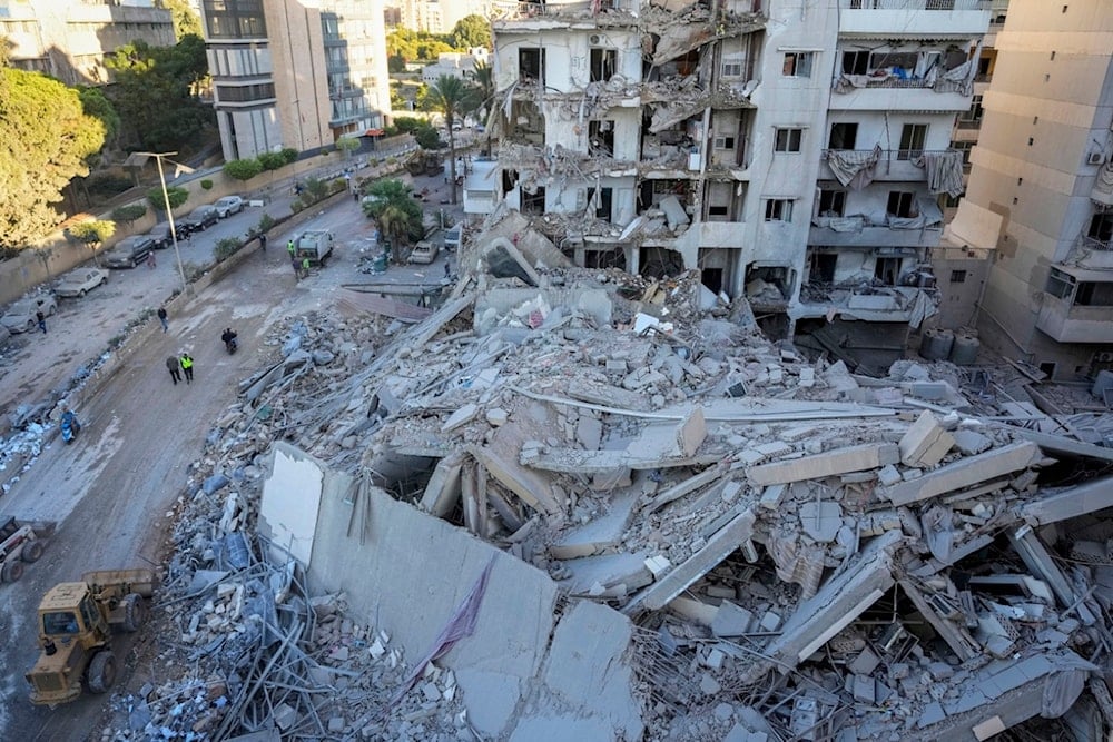 Rescue workers use a bulldozer to remove rubble of destroyed buildings at the site of an Israeli airstrike in Beirut's southern suburb, Lebanon, Oct. 21, 2024 (AP)