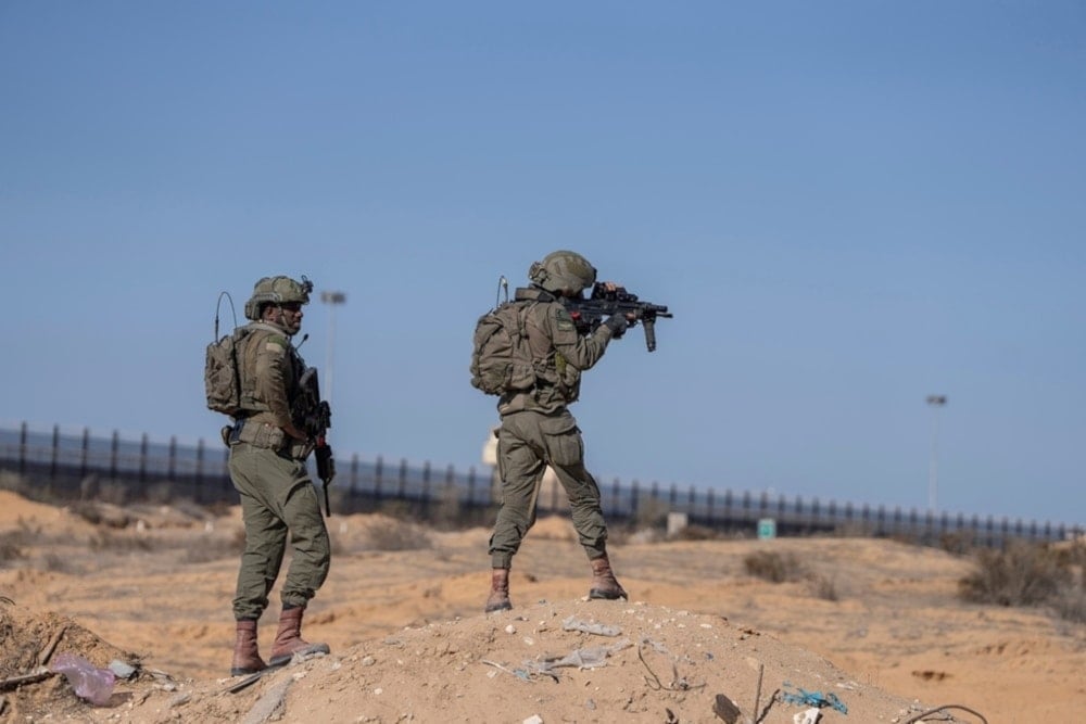 Israeli soldiers stand guard on the Palestinian side of the Karam Salem crossing as reporters tour the area in the Gaza Strip, on Thursday, December 19, 2024. (AP)