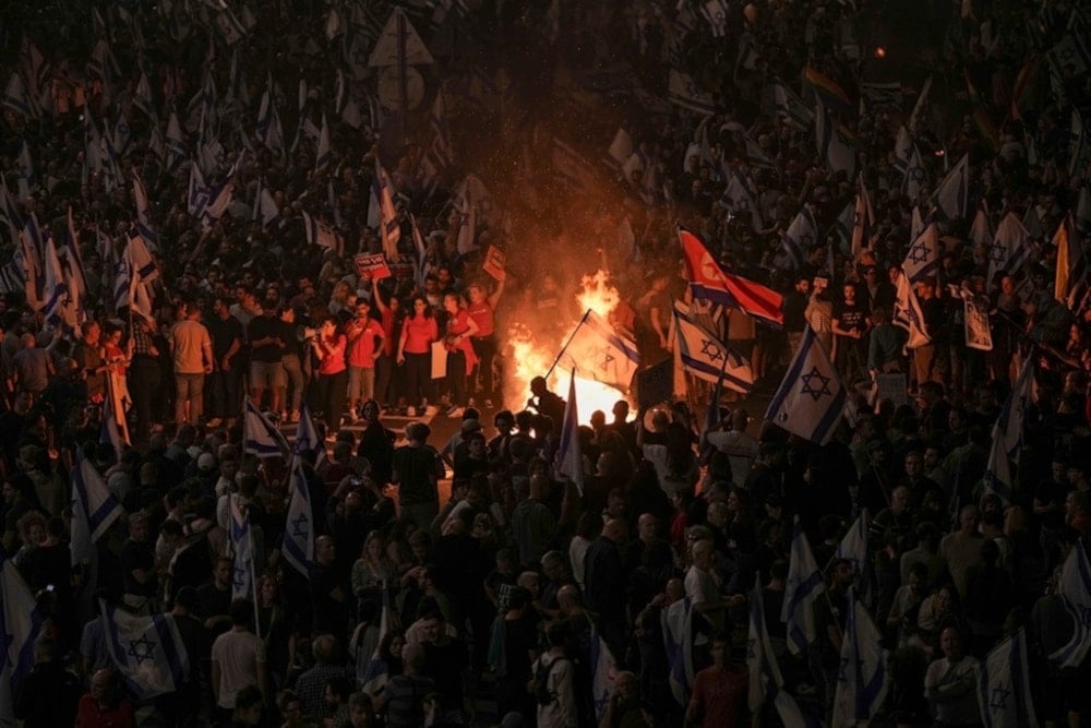 Israeli settlers light a bonfire during a protest after Prime Minister Benjamin Netanyahu has dismissed Security minister Yoav Gallant in Tel Aviv, occupied Palestine, Tuesday, November 5, 2024. (AP)