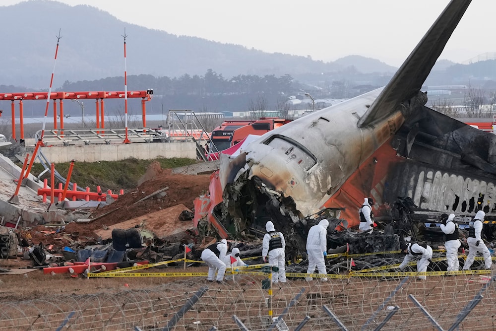 Rescue team members work at the site of a plane crash at Muan International Airport in Muan, South Korea, December 31, 2024. (AP)