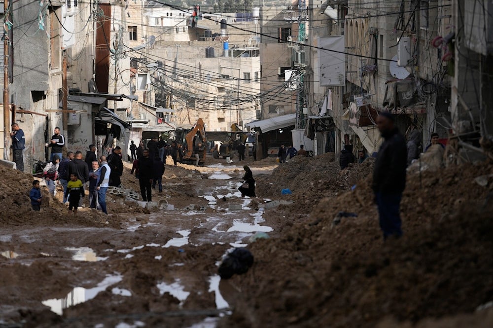 A woman crosses a damaged street after the latest Israeli military operation, in the West Bank city of Tulkarm, on December 26, 2024. (AP)