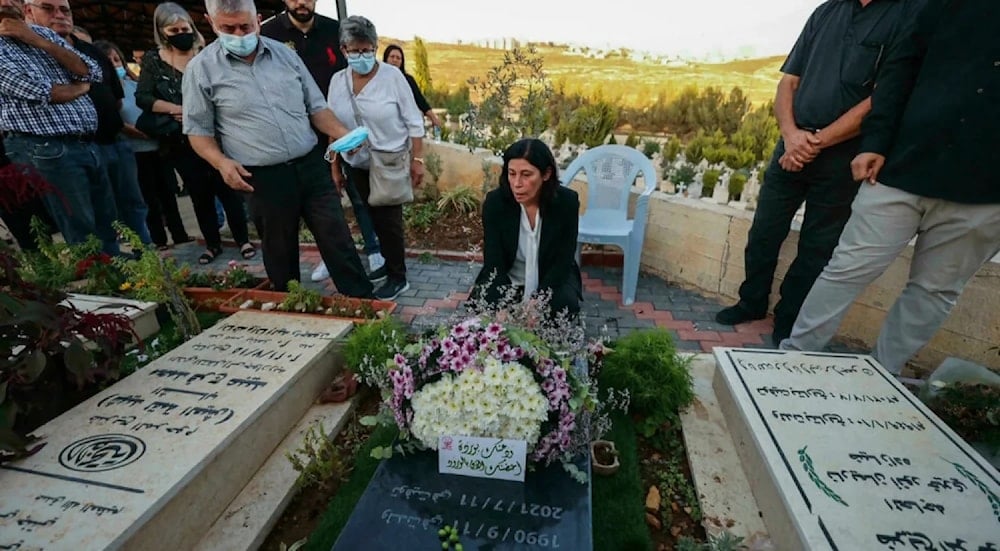 Khalida Jarrar on her daughter's grave after she was liberated from prison in 2021. (Social Media) 