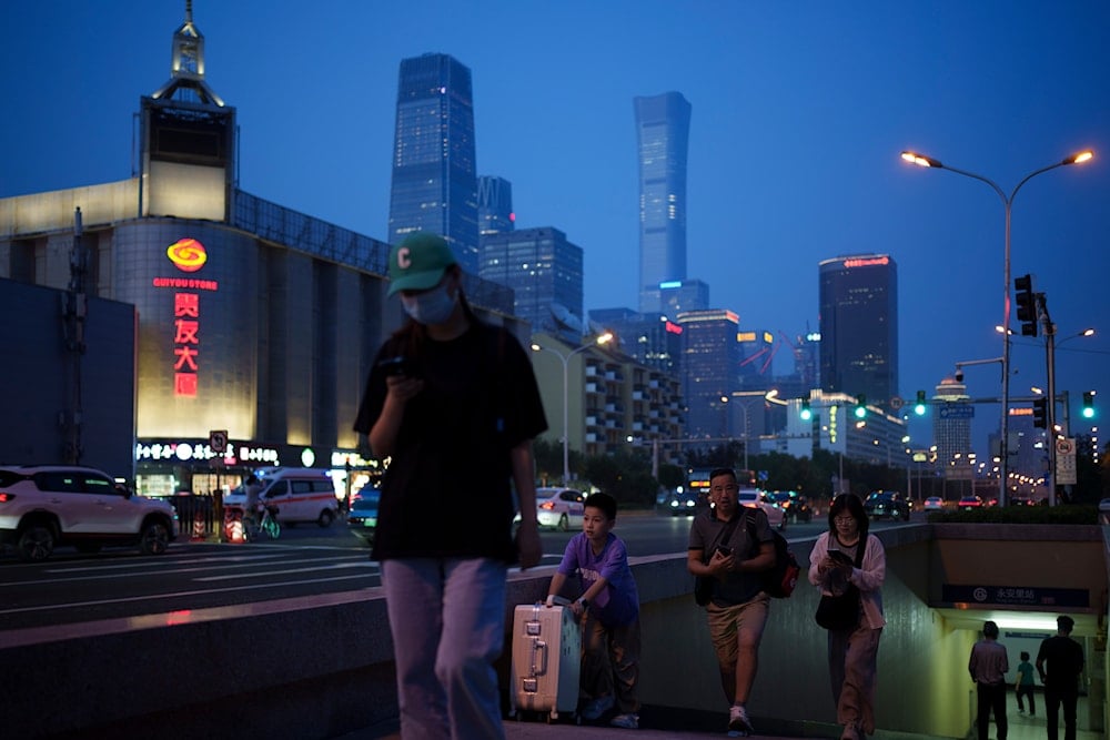 Pedestrian walk out from a underground cross way at evening in Beijing, China, on July 4, 2024. (AP)