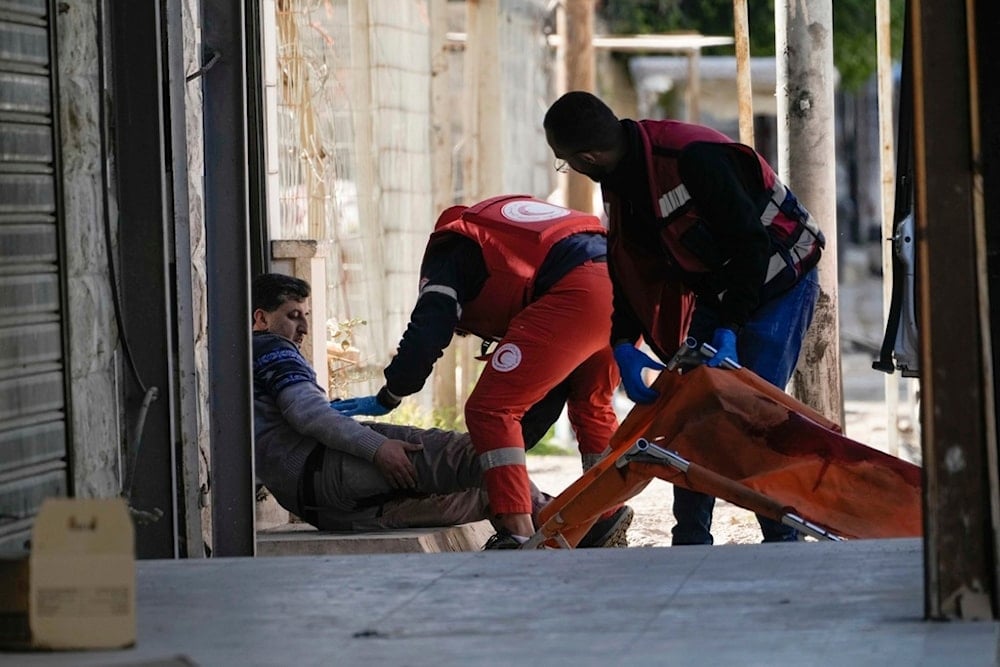 Medics evacuate a wounded man during an Israeli military operation in the West Bank city of Jenin, Tuesday, January 21, 2025 (AP)