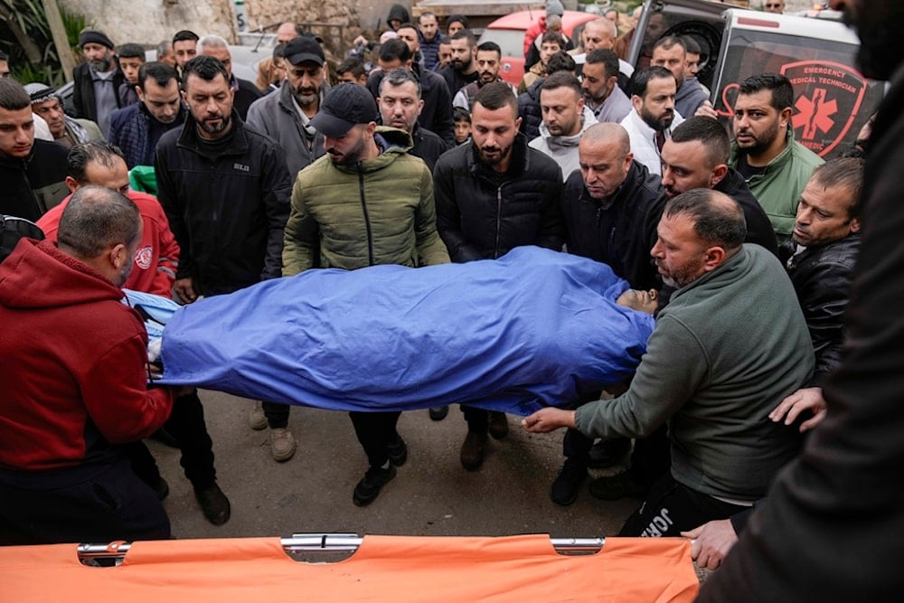 Mourners carry the body of Ahmad Al-Shayeb after he was killed during an Israeli military operation in Jenin, in the West Bank village of Bruqin, occupied Palestine, Wednesday, Jan. 22, 2025 (AP)