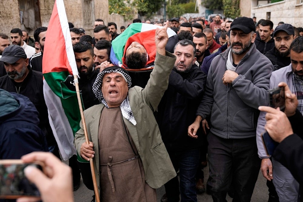 Mourners carry the body of Ahmad al-Shayeb after he was killed during an Israeli military operation in Jenin, in the West Bank village of Bruqin, occupied Palestine, Wednesday, Jan. 22, 2025 (AP)