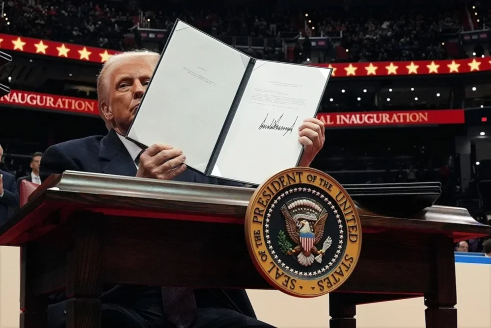 United States President Donald Trump signs an executive order as he attends an indoor Presidential Inauguration parade event at Capital One Arena, on January 20, 2025, in Washington. (AP)