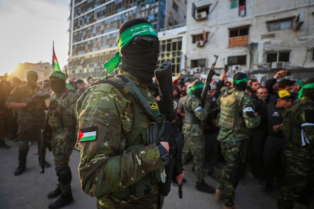 Fighters from the Qassam Brigades, the military wing of Hamas, control the crowd as Red Cross vehicles come to collect Israeli captives under a ceasefire agreement between the Israeli occupation and Hamas, in Gaza City, Jan. 19, 2025 (AP)