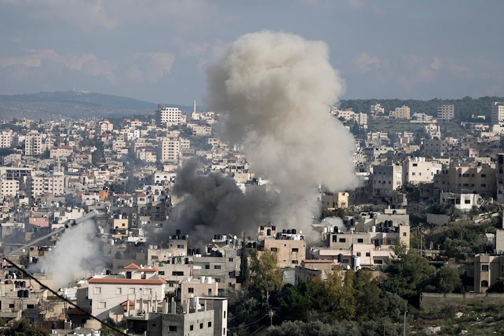 Smoke from an explosion billows as homes are demolished in Jenin refugee camp in the West Bank during an Israeli military operation, Friday, Jan. 24, 2025 (AP)