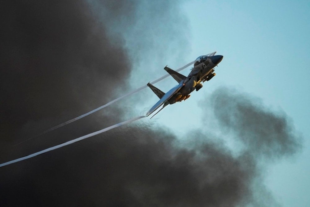 An Israeli air force F-15 war plane flies over during a graduation ceremony for news pilot in Hatzerim air force base near the southern city of Beer al-Sabe’, occupied Palestine, on Thursday, June 29, 2023. (AP)