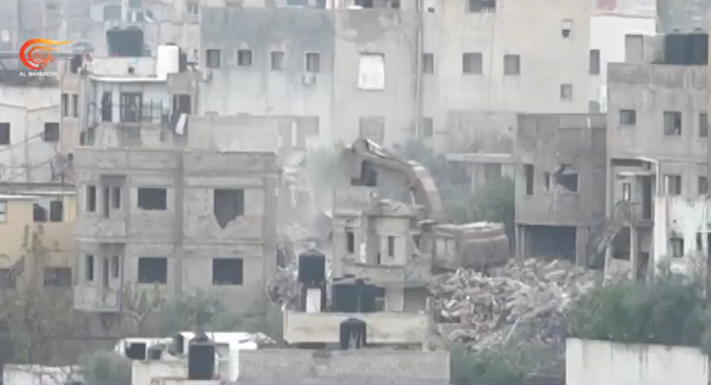 A screengrab form Al Mayadeen showing an Israeli bulldozer destroying Palestinian homes during its raid in Jenin Camp.