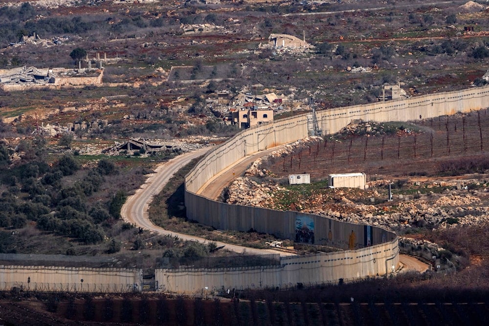 A wall marks the Israeli-Lebanese border near the village of Odaisseh in southern Lebanon, as seen from northern occupied Palestine, on January 23, 2025. (AP)