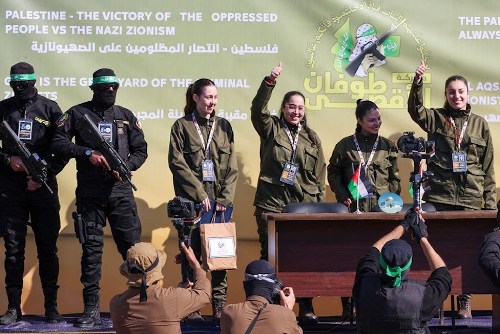 Israeli captives Liri Albag, Karina Ariev, Daniella Gilboa, Naama Levy wave from a stage in Gaza City at a Hamas-run event as they are released to the Red Cross. (AFP)