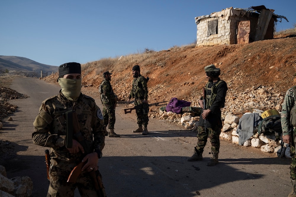 Members of the new security forces stand guard at a checkpoint located near the border with Lebanon, in the town of Serghaya, Syria, Tuesday, January 7, 2025 (AP)