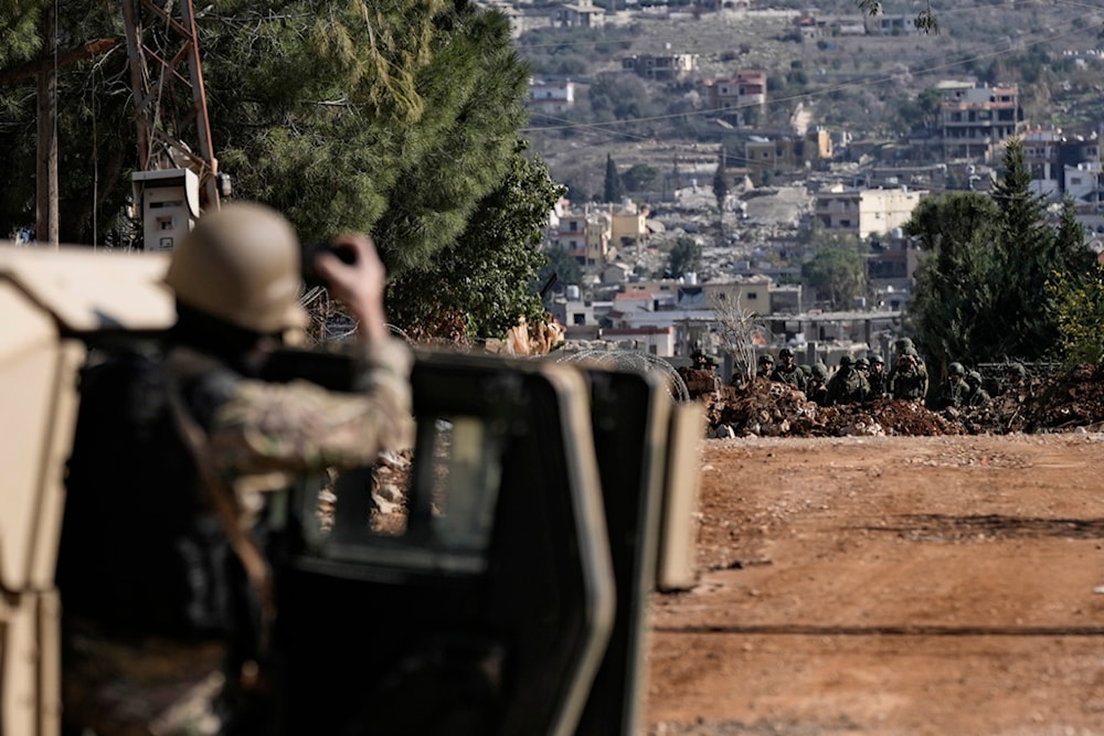 A Lebanese soldier filming as Israeli occupation forces block a road in the southern Lebanese village of Aitaroun, Lebanon, Monday, Jan. 27, 2025 (AP)