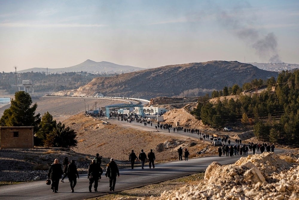 Residents of northeastern Syria walk towards the Tishrin Dam to join a sit-in demanding an end to the war in the region in Aleppo's countryside, Syria, Wednesday, Jan. 8, 2025 (AP)