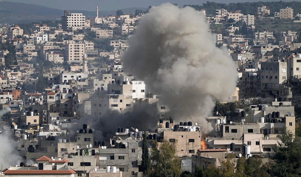 Smoke from an explosion billows as homes are demolished in Jenin refugee camp in the West Bank during an Israeli military operation, Friday, Jan. 24, 2025. (AP)