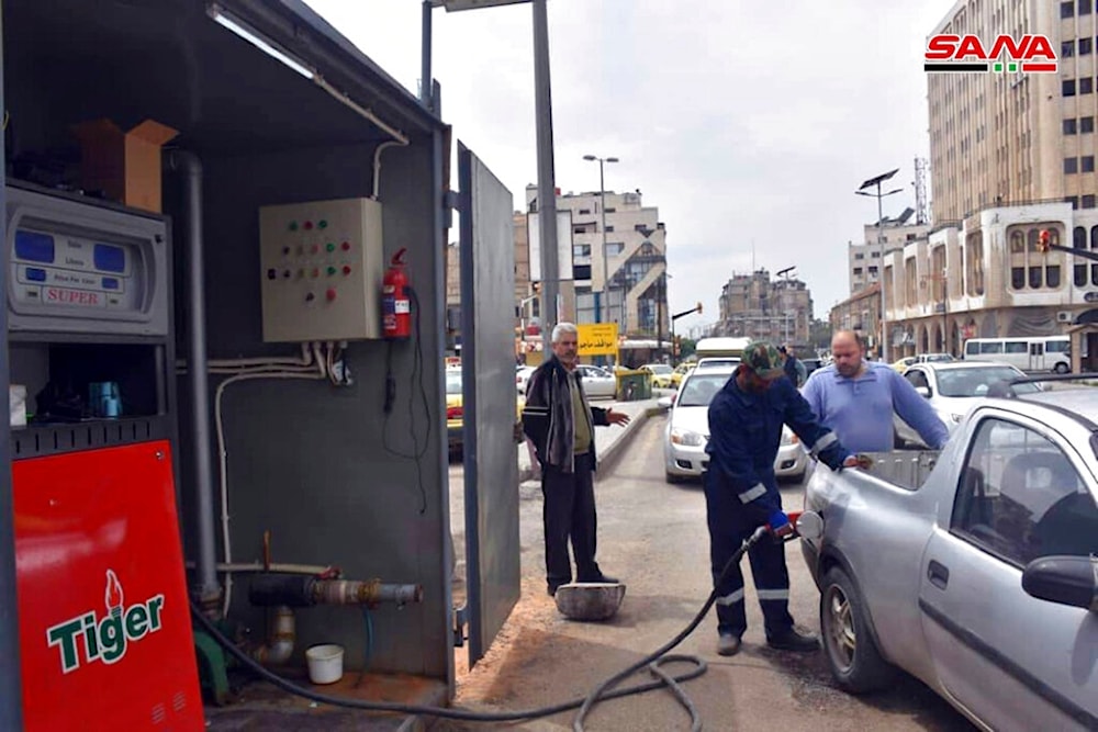 This file photo released on April 7, 2019, by the Syrian official news agency SANA, shows a worker filling a pickup at a gas station, in Homs, Syria (SANA)