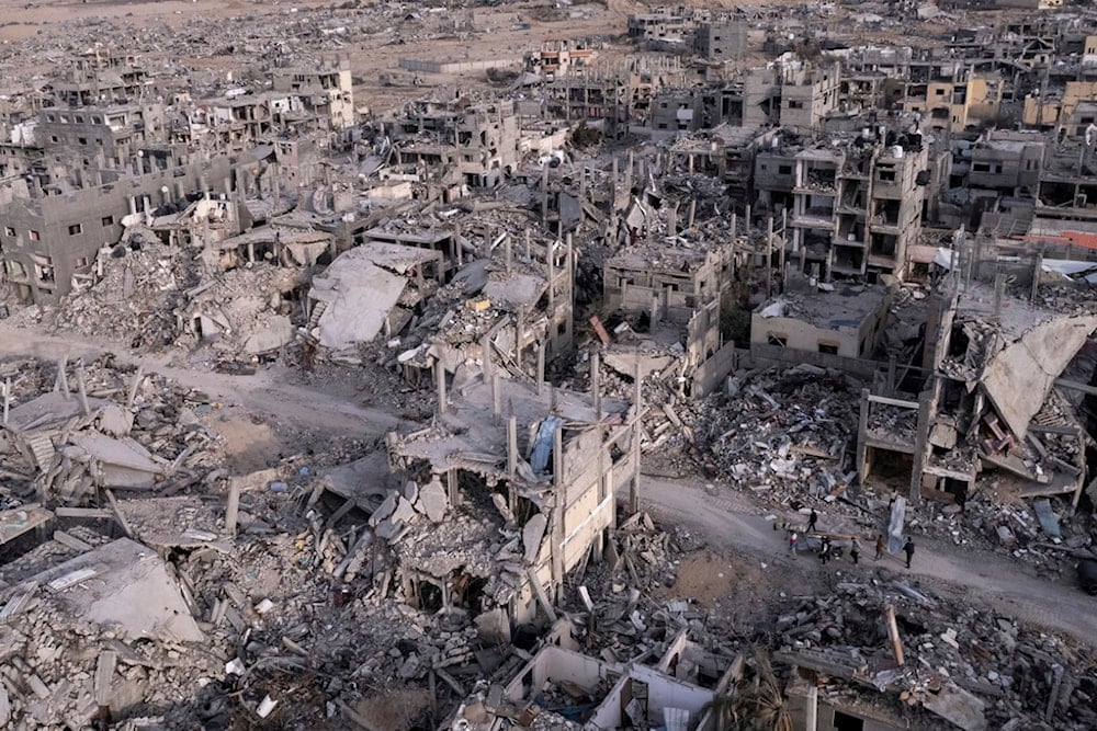 An aerial photograph taken by a drone shows Palestinians walking through the destruction caused by the Israeli air and ground offensive, in Rafah, Gaza Strip, Tuesday, Jan. 21, 2025 (AP)