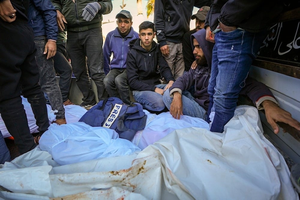 Colleagues and friends mourn over the body of a Palestinian martyr after overnight Israeli occupation forces strikes at multiple locations in central Gaza Strip, at al-Aqsa Martyrs Hospital in Deir al-Balah, Friday, January 3, 2025 (AP)