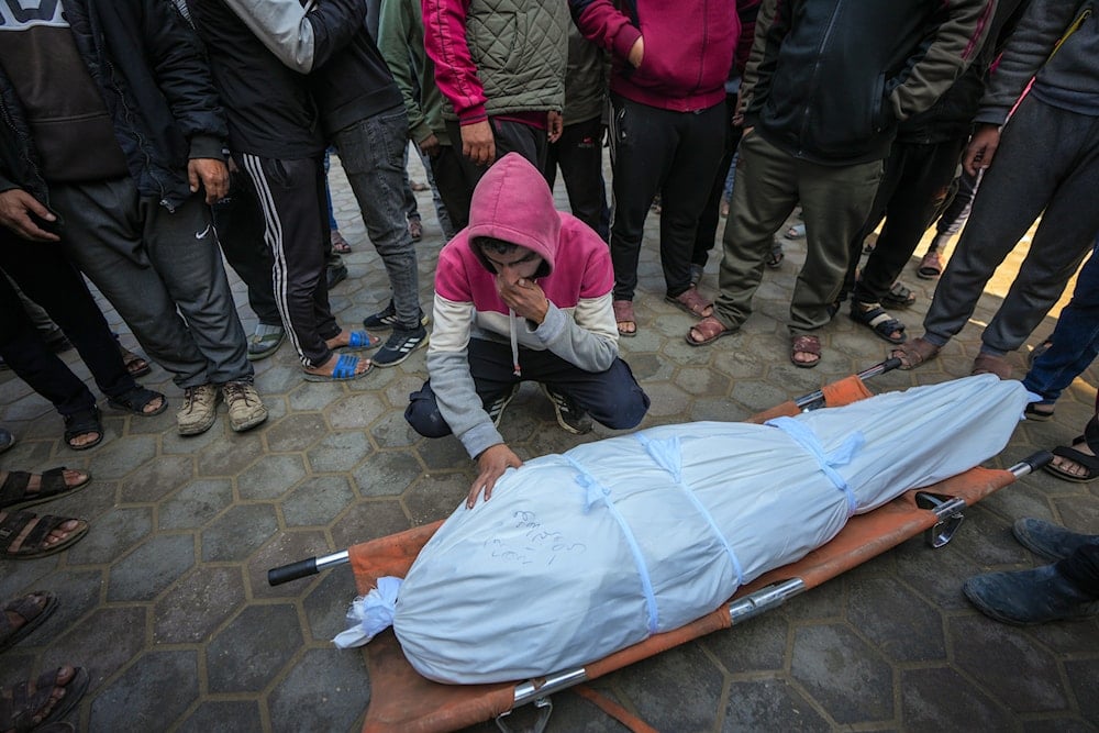 A man mourns over the body of a Palestinian man killed during an Israeli army strike in Deir al-Balah in the central Gaza Strip, on January 2, 2025. (AP)