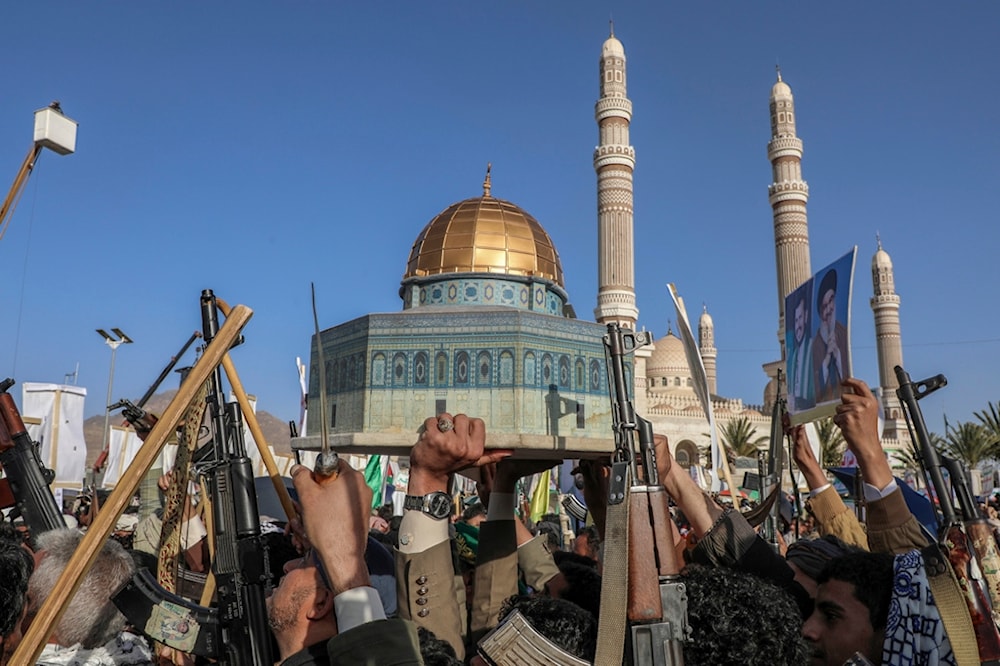 Yemenis hold a replica of Al-Aqsa Mosque and raise their machine guns during a pro-Palestine rally in Sanaa, Yemen, Friday, Dec. 27, 2024. (AP)