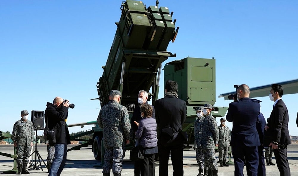 NATO Secretary-General Jens Stoltenberg, center with a protective mask, is guided to inspect a PAC-3 interceptor missile system at Iruma Air Base in Sayama, northwest of Tokyo, Tuesday, Jan. 31, 2023. (AP)