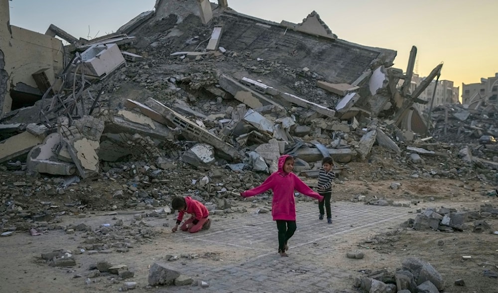 Palestinian children play next to a building destroyed by Israeli army strikes in the central Gaza Strip town of Khan Younis, Wednesday, Jan. 1, 2025. (AP)