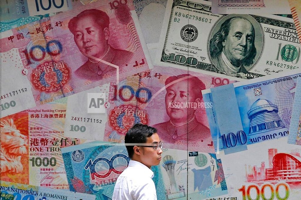 In this June 10, 2019, file photo, a man walks past a money exchange shop decorated with different banknotes at Central, a business district of Hong Kong. (AP)