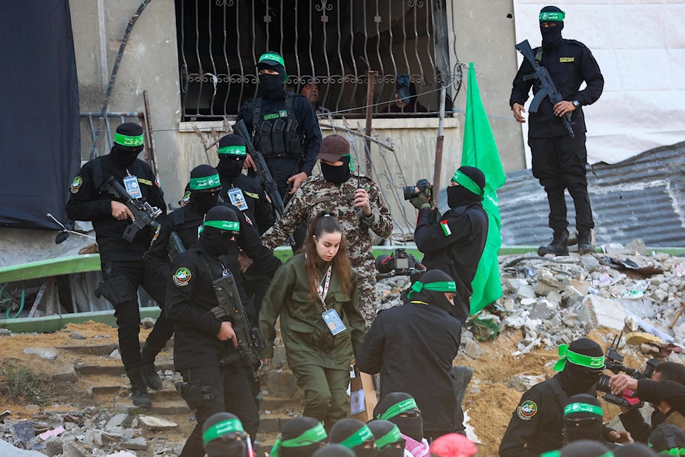 Israeli soldier Agam Berger is escorted out of a damaged building and onto a stage in northern Gaza’s Jabalia before she is handed over to the Red Cross on January 30, 2025 (AFP)