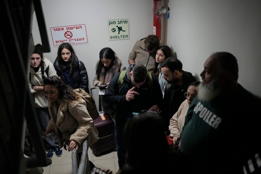 Israeli settlers gather in a shelter after airstrike sirens sounded off in Ben Gurion Airport, near Tel Aviv, occupied Palestine, early Friday, Jan. 3, 2024 (AP)