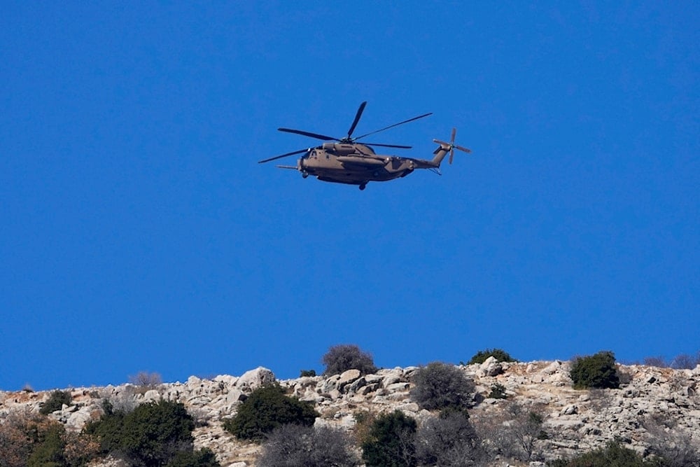 An Israeli Air Force Black Hawk helicopter flies over Mount Hermon near the so-called Alpha Line that separates the Israeli-occupied Golan Heights from the remainder of Syria, viewed from the town of Majdal Shams, Tuesday, December 17, 2024 (AP)