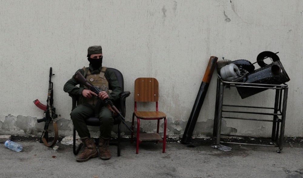 A member of the security forces of the newly formed Syrian government looks on as members of Bashar al-Assad’s army line up to register as part of ‘identification and reconciliation’ process in Damascus, Syria, December 30,2024. (AP)