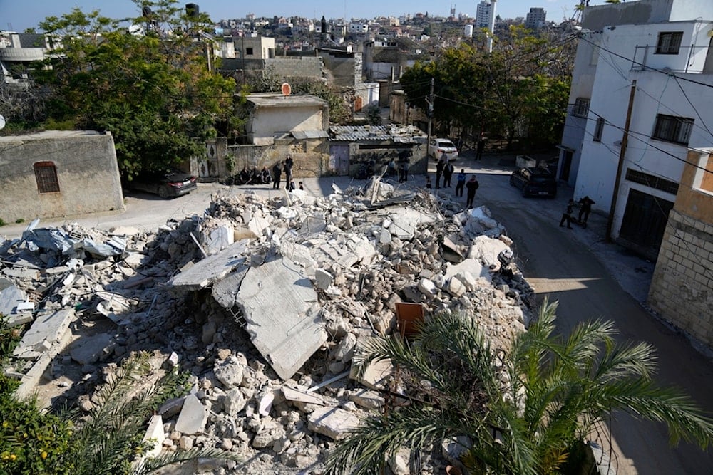 Residents gather by the rubble of the family home of Mohammad Abu Yassin, which was demolished by Israeli occupation forces in the West Bank town of Bal'a, occupied Palestine, Thursday, Jan. 2, 2025 (AP)