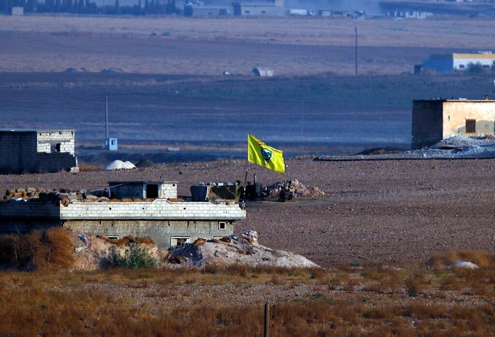 A flag of the Kurdish People's Protection Units, or YPG, flies on a building in Akcakale, Sanliurfa province, southeastern Turkey, Wednesday, Oct. 9, 2019 (AP)