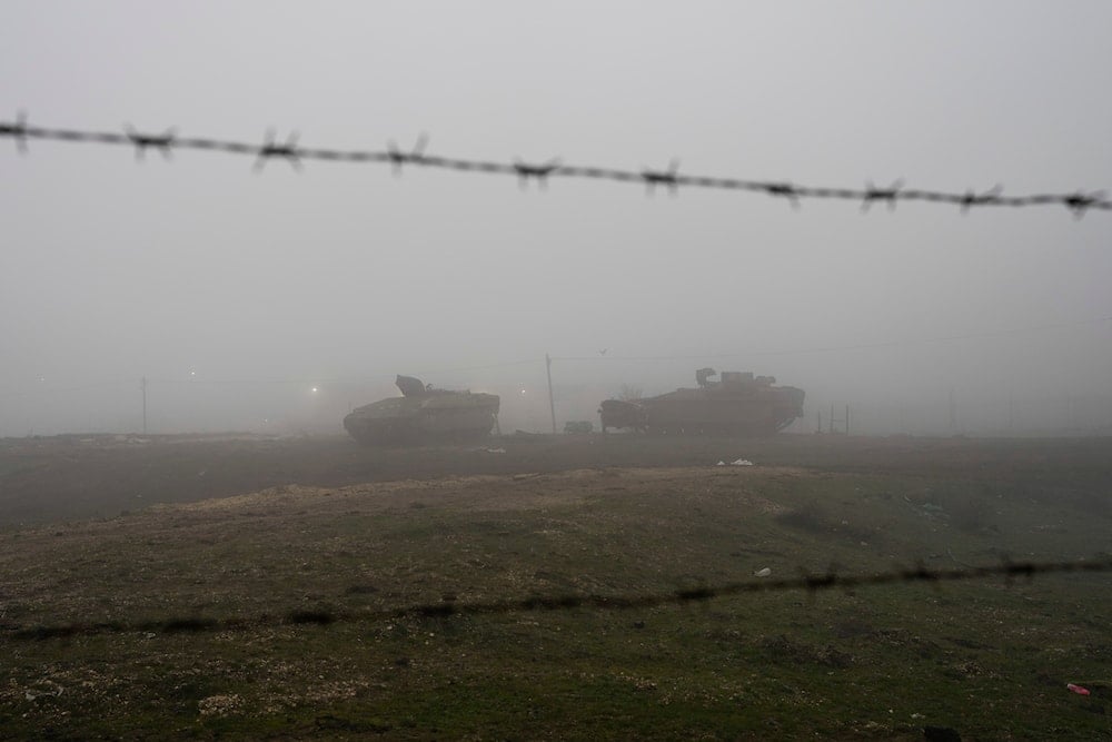 Israeli armoured vehicles park on the side of a road in the Israeli-controlled Golan Heights, on a foggy on December 22, 2024. (AP)