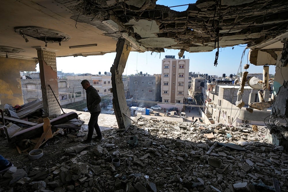 A Palestinian looks at a damaged residential building following an overnight Israeli strike in Deir al-Balah, Gaza Strip, on January 8, 2025. (AP)