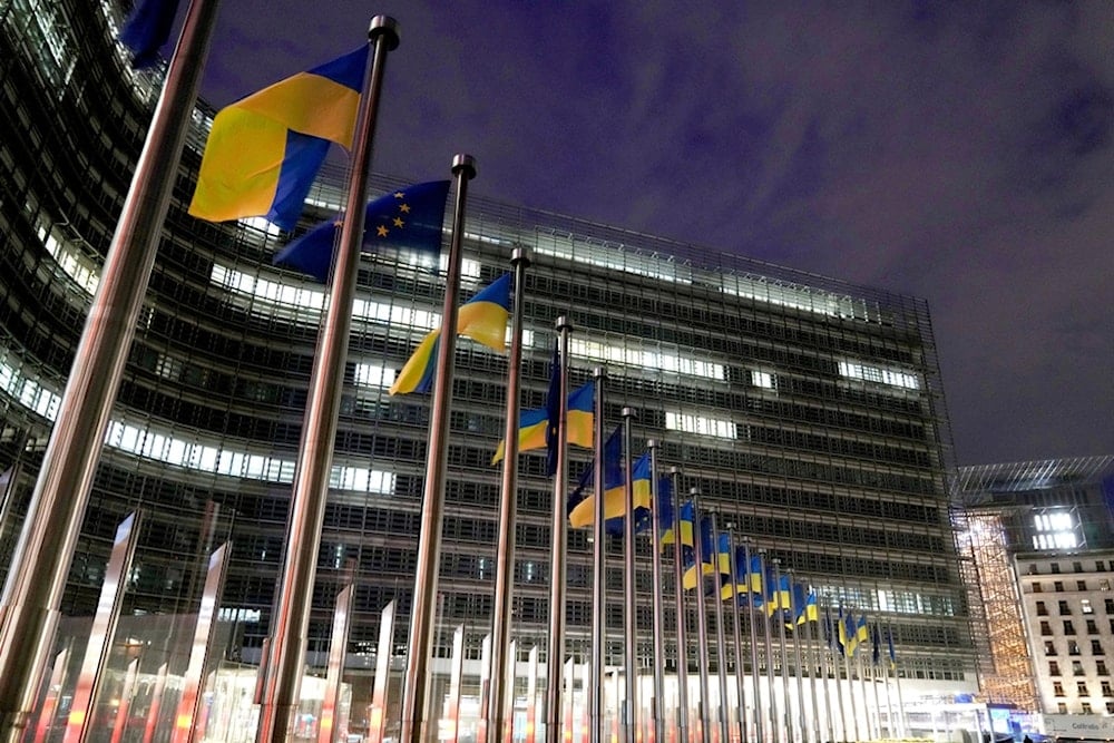 European Union and Ukrainian flags flap in the wind on the day to mark the third anniversary of the Russia-Ukraine war, at EU headquarters in Brussels, Monday, February 24, 2025. (AP Photo/Virginia Mayo)