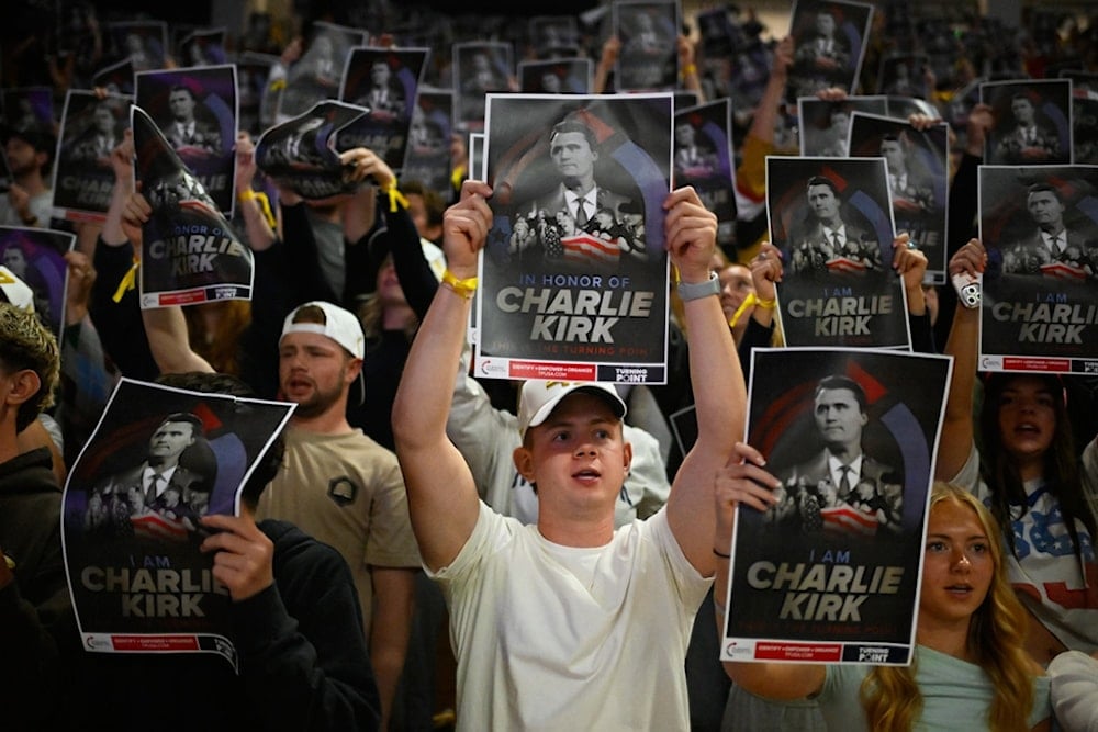 People hold posters of Charlie Kirk during a Turning Point USA rally at Utah State University, as a part of the organization's push to memorialize Kirk, Tuesday, September 30, 2025, in Logan, Utah. (AP Photo/Alex Goodlett)