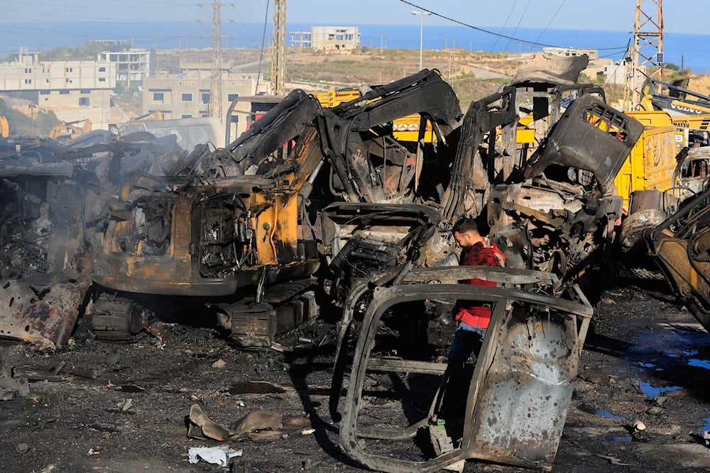 A man walks at a site that sold heavy machinery, where a large number of vehicles were destroyed in Israeli airstrikes, in the southern village of Msayleh, Lebanon, Saturday, Oct. 11, 2025 (AP)