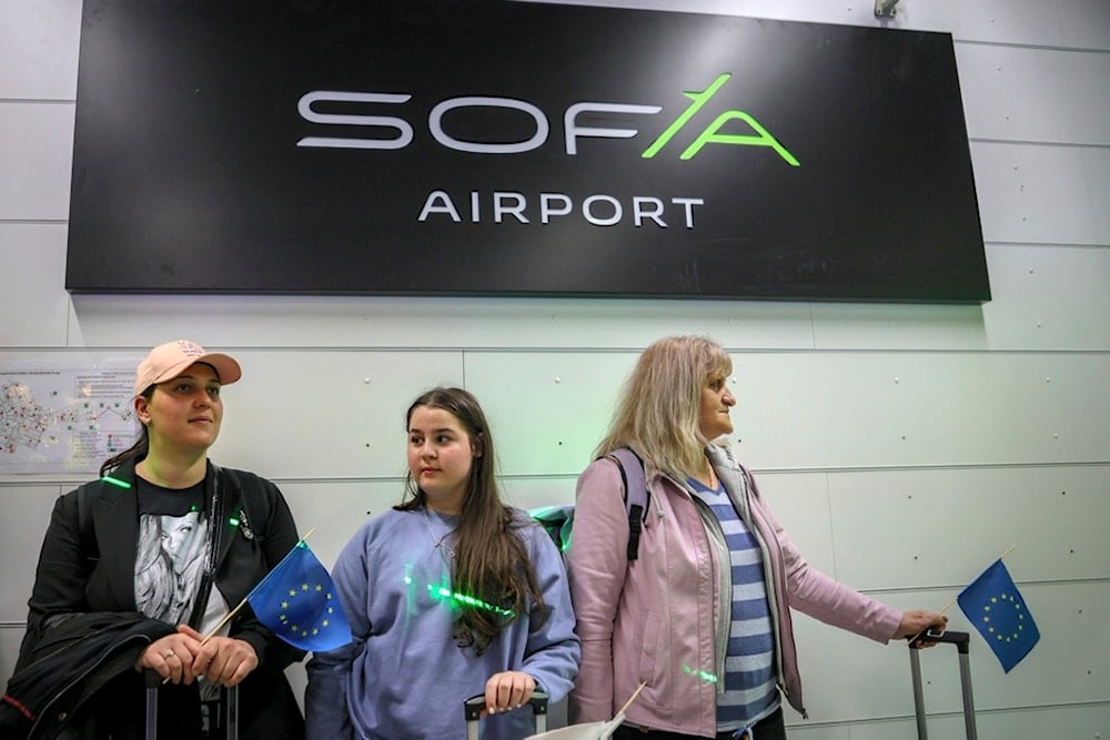 Passengers coloured by green light attend a welcoming ceremony announcing Bulgaria's accession in Schengen by air and water, at Sofia airport, Bulgaria, Sunday, March 31, 2024 (AP)