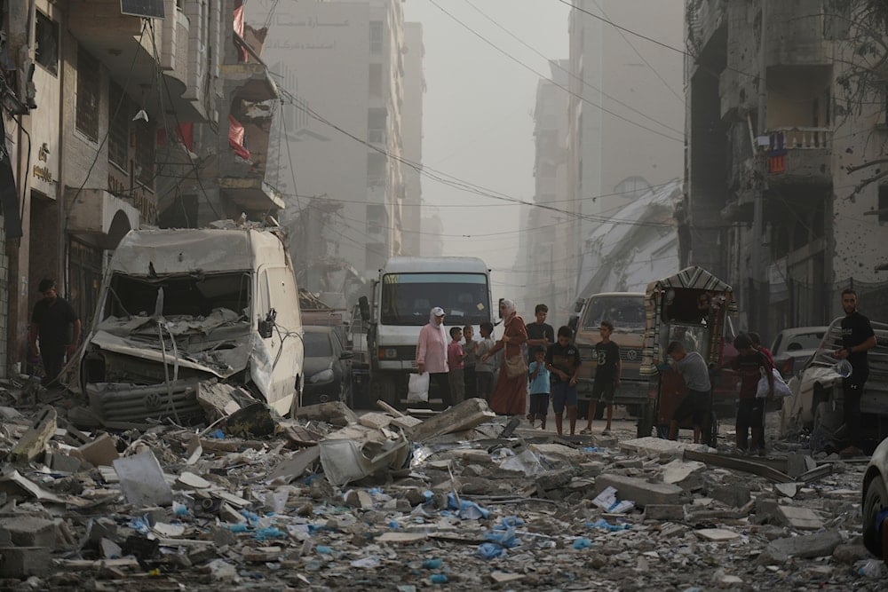 Palestinians stand next to a heavily damaged building in the Rimal neighborhood, in Gaza City, Sunday, Aug. 31, 2025, a day after it was hit by an Israeli military strike that killed several people. (AP Photo/Jehad Alshrafi)
