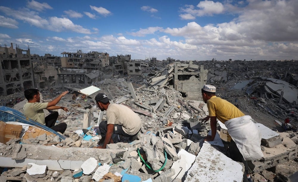 Palestinians search through the rubble of buildings destroyed by Israeli airstrikes in Khan Younis, in southern Gaza, on October 12, 2025. (AFP)