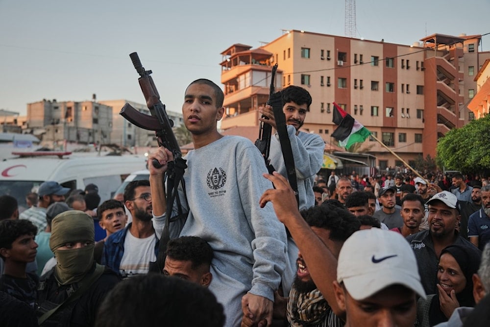 Freed Palestinian prisoners carry rifles as they arrive in the Gaza Strip following their release from Israeli jails, outside Nasser Hospital in Khan Younis, southern Gaza Strip, Monday, October 13, 2025 (AP)