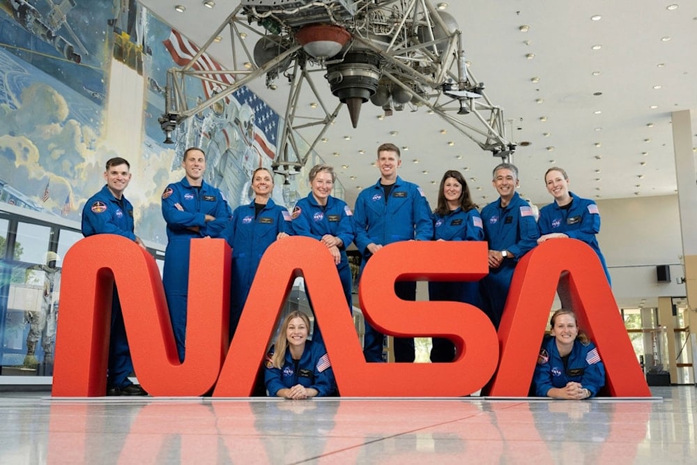 In this undated photo released by NASA, NASA's 10 newest astronauts pose behind the logo at at NASA’s Johnson Space Center in Houston, Texas (AP)