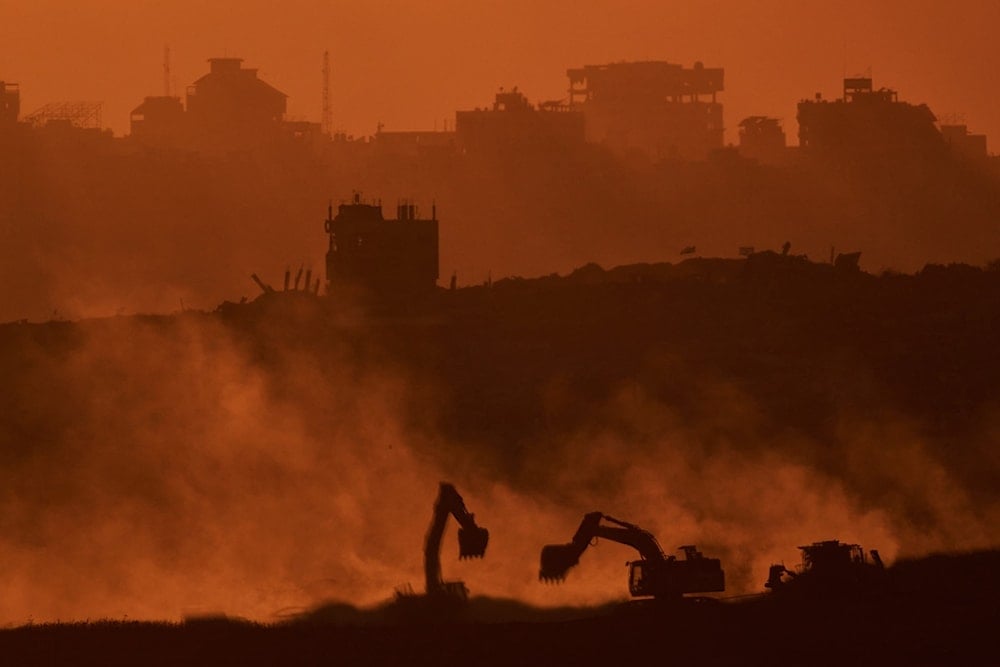 Israeli excavators work in the Gaza Strip as the sun sets, seen from southern occupied Palestine, Tuesday, Oct. 14, 2025 (AP)