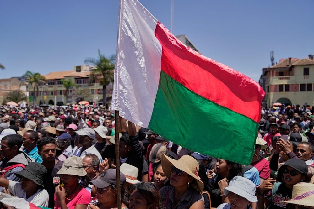 Protesters listen to speeches during a protest calling for President Andry Rajoelina to step down in Antananarivo, Madagascar, Tuesday, Oct. 14, 2025. (AP Photo/Brian Inganga)