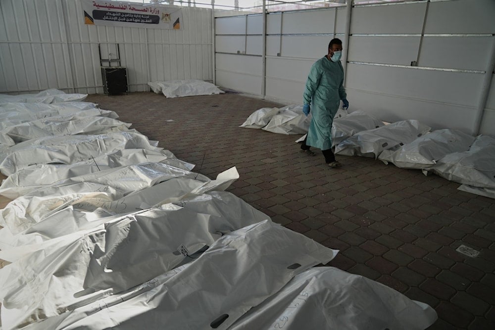 The bodies of deceased Palestinians, held by the Israeli regime during the war, lie in plastic bags on the floor of Nasser Hospital in Khan Younis, Gaza, following their release, Wednesday, October 15, 2025 (AP)
