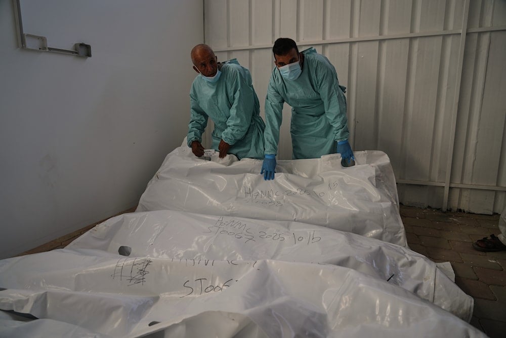The bodies of deceased Palestinians, held by Israel during the war, lie in plastic bags on the floor of Nasser Hospital in Khan Younis, Gaza, following their release, Wednesday, Oct. 15, 2025 (AP)