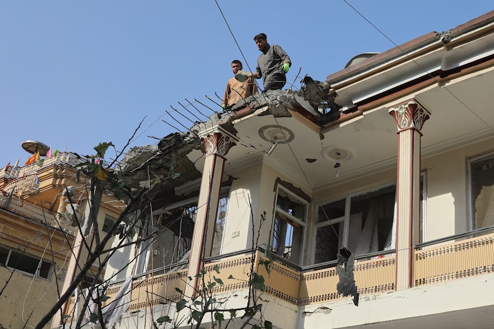 Residents stand on the roof of a damaged house as they inspect the destruction caused by Wednesday's two drone strikes, in Kabul, Afghanistan, Thursday, Oct. 16, 2025 (AP)